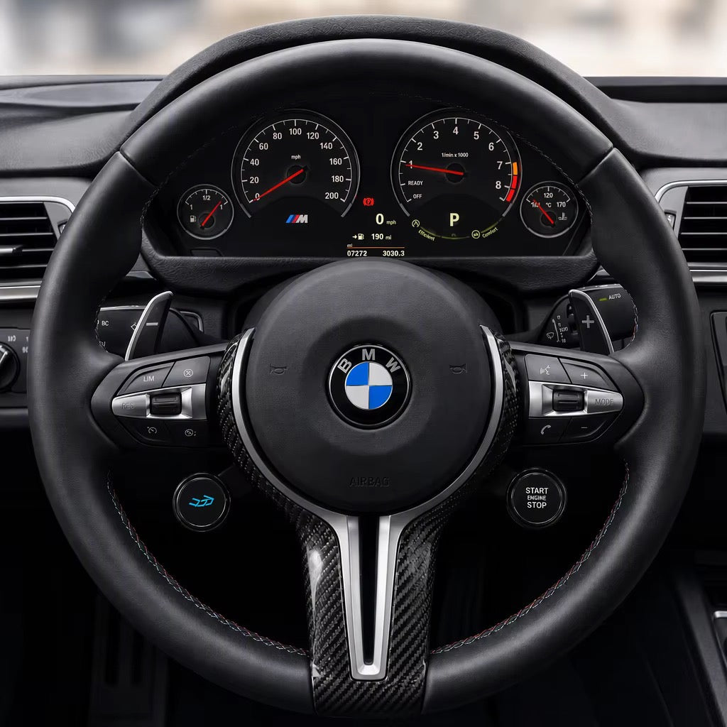 OLED display knobs on the lower spokes of an F Series BMW M steering wheel